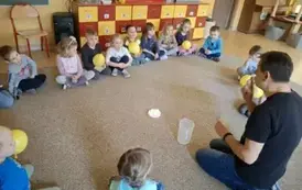 dzieci siedzą w kole