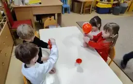 dzieci wsypują proszek do balon&oacute;w
