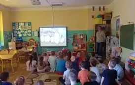 dzieci oglądają film edukacyjny na tablicy multimedialnej