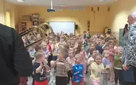 dzieci słuchają gry na trąbce