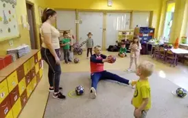 instruktor pokazuje dzieciom ćwiczenia