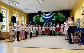 dzieci stoją w p&oacute;łkolu na sali