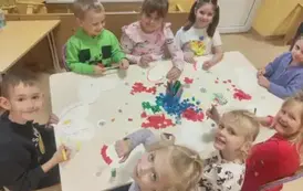 dzieci wyklejają z kolorowego papieru szablon