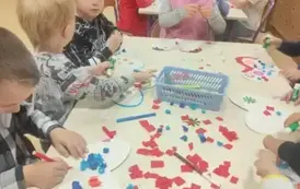 dzieci robią wyklejanke z kolorowego papieru