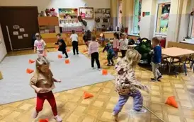 dzieci slalomem toczą piłki