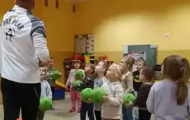 dzieci stoją trzymając piłki