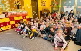 dzieci siedzą i oglądają teatrzyk