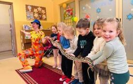 dzieci trzymają na rękach węża