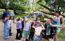 dzieci zwiedzają park dinozaur&oacute;w