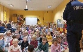 Dzieci słuchają pogadanki policjant&oacute;w na temat bezpieczeństwa