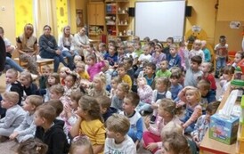 Dzieci słuchają pogadanki policjant&oacute;w na temat bezpieczeństwa