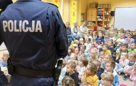 Dzieci słuchają pogadanki policjant&oacute;w na temat bezpieczeństwa