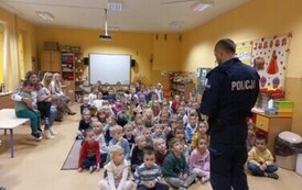 Policjanci prowadzą prelekcję dla dzieci na temat bezpieczeństwa na drodze