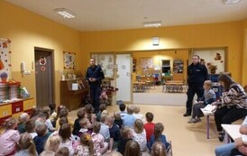 Policjanci prowadzą prelekcję dla dzieci na temat bezpieczeństwa na drodze