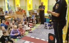 Dzieci słuchają pogadanki strażnik&oacute;w miejskich na temat bezpiecznego poruszania się po drodze