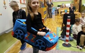 dziewczynka jedzie zabawkowym samochodem