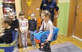 dziewczynka jedzie zabawkowym samochodem