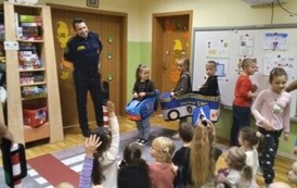 Dzieci słuchają pogadanki strażnik&oacute;w miejskich na temat bezpieczeństwa
