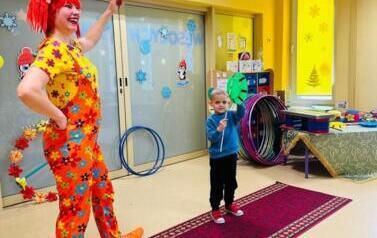 dziecko z cyrkowcem kręcą talerze na patyczkach