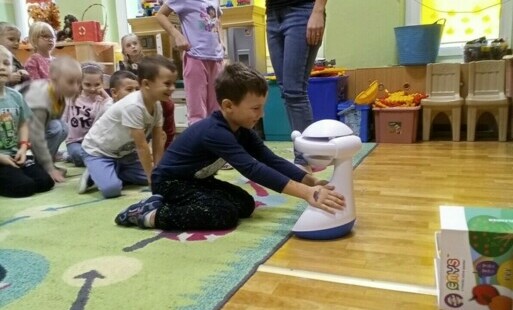 chłopiec dotyka robota EMYSa