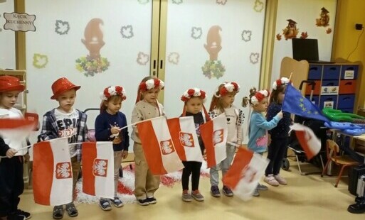 dzieci w strojach biało-czerwonych z flagami Polski