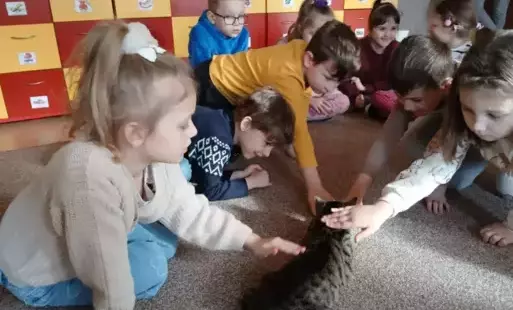 dzieci głaszczą kota