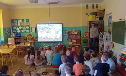 dzieci oglądają film edukacyjny na tablicy multimedialnej