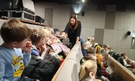 dzieci w kinie rozmawiają z panią prowadzącą