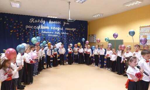 dzieci ustawione w półkolu trzymają w rękach kolorowe balony